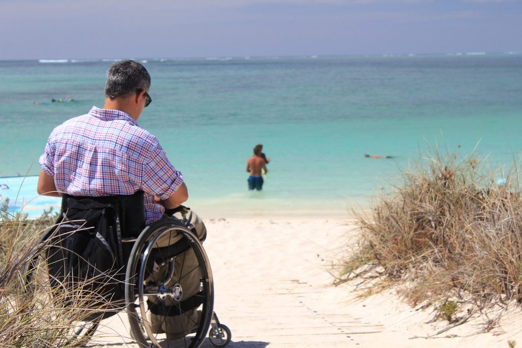 איש בכיסא גלגלים בחוף ים
